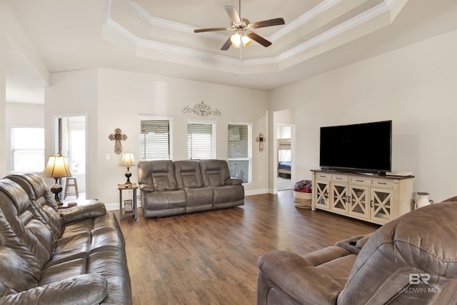 living area with crown molding, a ceiling fan, dark wood finished floors, and a tray ceiling