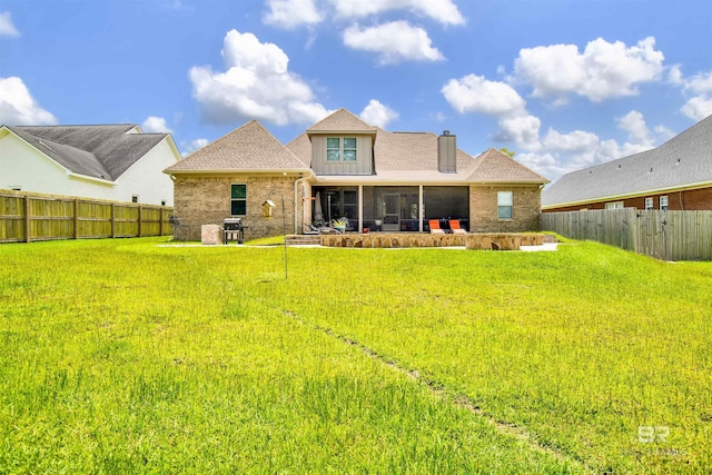 5698 Spring Landing Dr, Theodore, AL 36582 - rear view of house with brick siding, a sunroom, a fenced backyard, a chimney, and a shingled roof