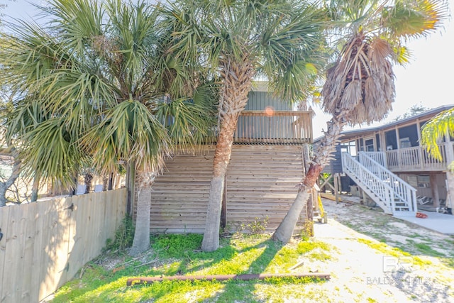 684 Chickasaw Rd, Gulf Shores, AL 36542 - view of side of property with stairs, a sunroom, and a wooden deck