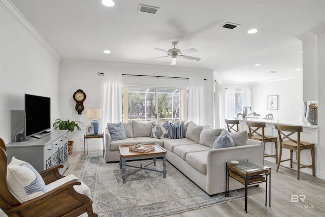 living area with a wealth of natural light, ornamental molding, and visible vents