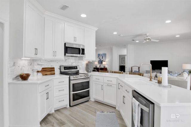 kitchen featuring visible vents, a sink, open floor plan, stainless steel appliances, and recessed lighting