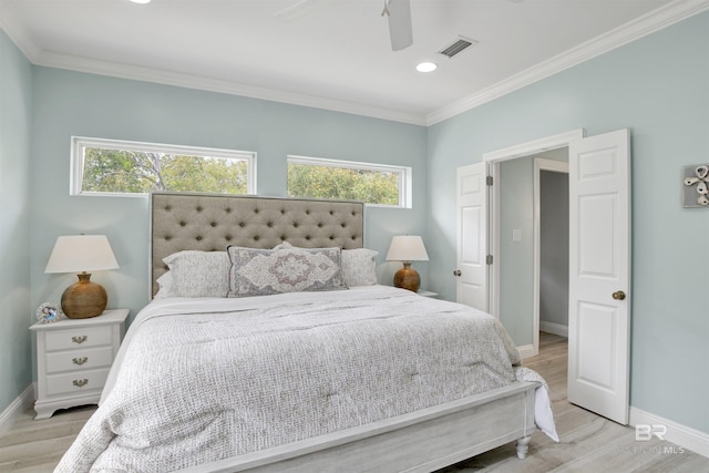 bedroom with crown molding, multiple windows, light wood-style flooring, baseboards, and visible vents