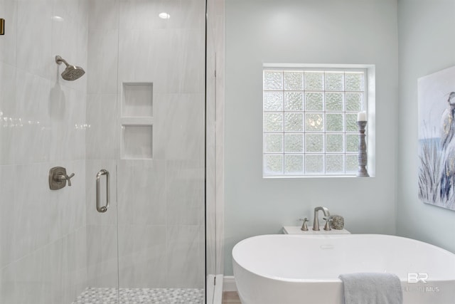full bathroom with a freestanding tub and a shower stall