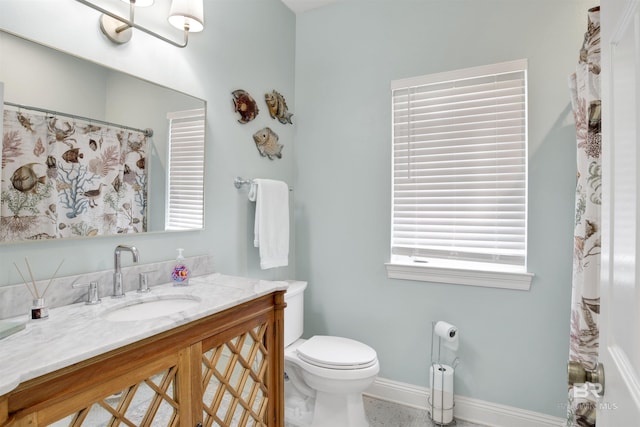 bathroom with toilet, baseboards, and vanity