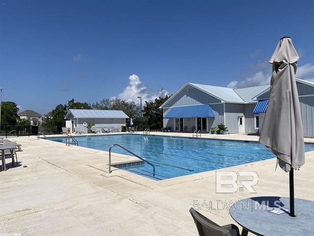 pool featuring fence and a patio area