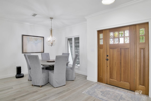 dining area with visible vents, light wood-type flooring, baseboards, a notable chandelier, and ornamental molding