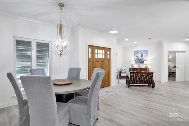 dining room featuring an inviting chandelier, baseboards, ornamental molding, and light wood-type flooring