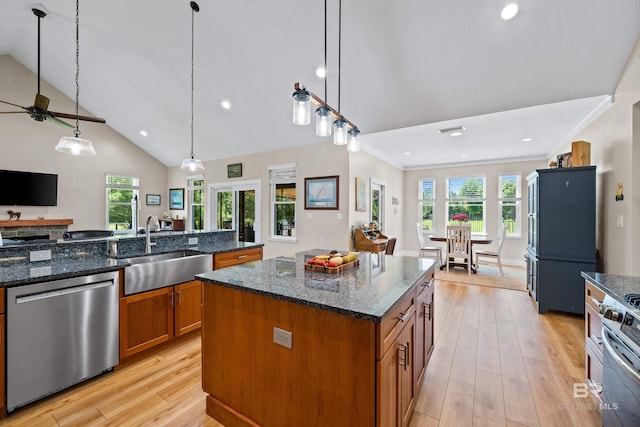 1609 Makaira Dr, Foley, AL 36535 - kitchen featuring stainless steel appliances, a sink, a kitchen island, brown cabinetry, and light wood-style flooring