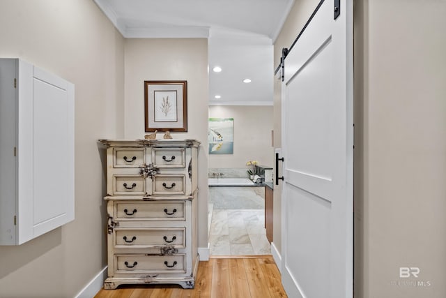 1609 Makaira Dr, Foley, AL 36535 - hallway with a barn door, light wood-style floors, ornamental molding, recessed lighting, and baseboards