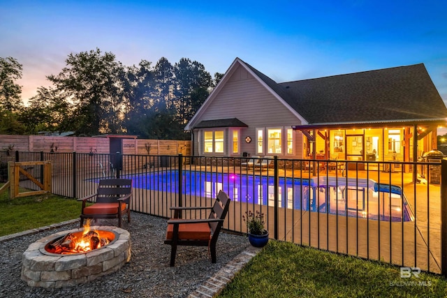 1609 Makaira Dr, Foley, AL 36535 - pool at dusk with an outdoor fire pit, a fenced backyard, and a patio