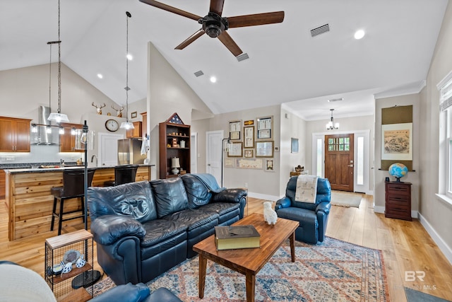 1609 Makaira Dr, Foley, AL 36535 - living room with baseboards, ceiling fan, light wood-style flooring, a chandelier, and high vaulted ceiling