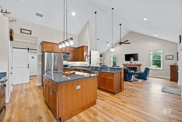 1609 Makaira Dr, Foley, AL 36535 - kitchen featuring stainless steel appliances, brown cabinets, open floor plan, a peninsula, and high vaulted ceiling