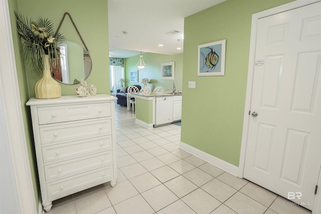 hallway featuring light tile patterned floors, recessed lighting, a sink, visible vents, and baseboards