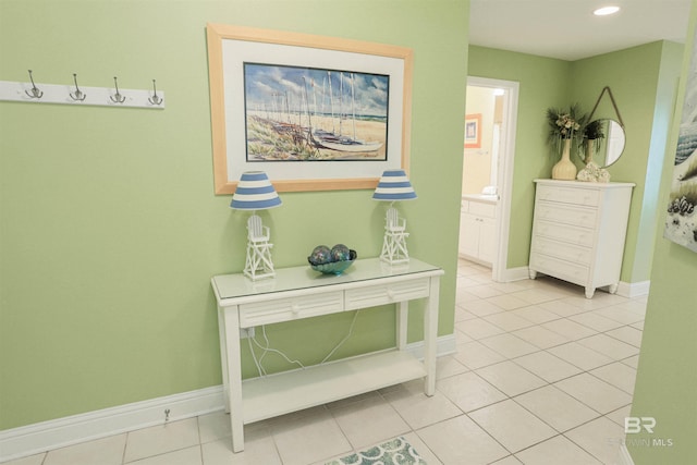 corridor featuring light tile patterned floors, baseboards, and recessed lighting