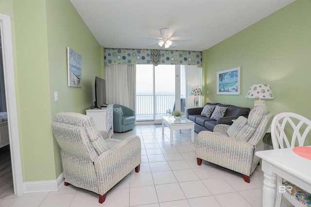 living area featuring light tile patterned floors, baseboards, and a ceiling fan