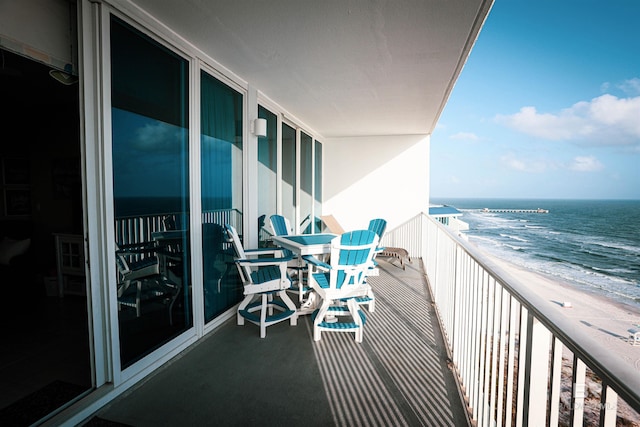 balcony with a beach view and a water view