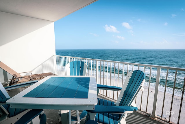 balcony featuring a view of the beach and a water view