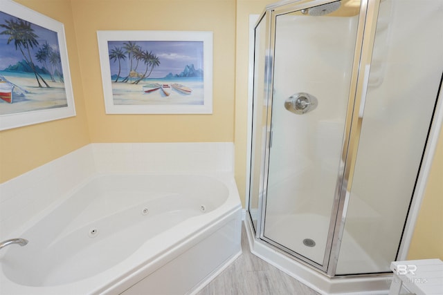 bathroom with a shower stall and a tub with jets