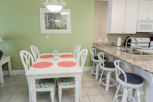 dining space with light tile patterned flooring and baseboards