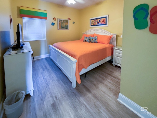 bedroom featuring baseboards and wood finished floors