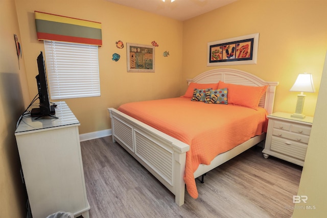 bedroom with baseboards and wood finished floors