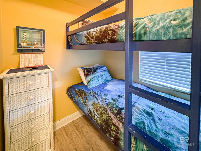 bedroom with baseboards and wood finished floors