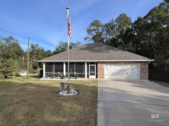 view of front of property featuring a sunroom, a front lawn, and a garage