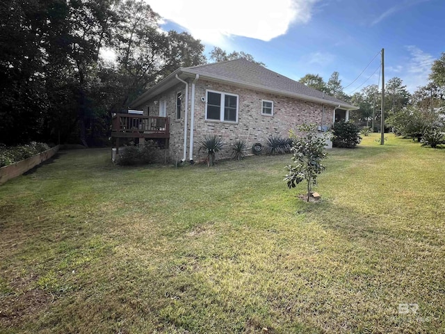 view of side of home with a yard and a deck