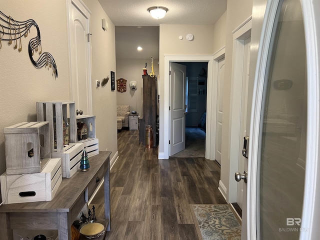 hall with dark wood-type flooring and a textured ceiling