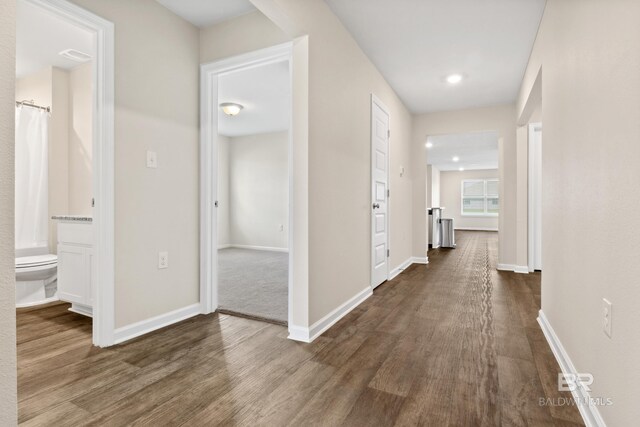 kitchen featuring light hardwood / wood-style flooring, stainless steel appliances, white cabinetry, and a center island with sink