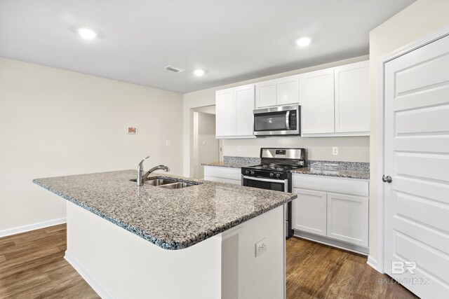 kitchen featuring sink, an island with sink, white cabinetry, light hardwood / wood-style flooring, and stainless steel appliances