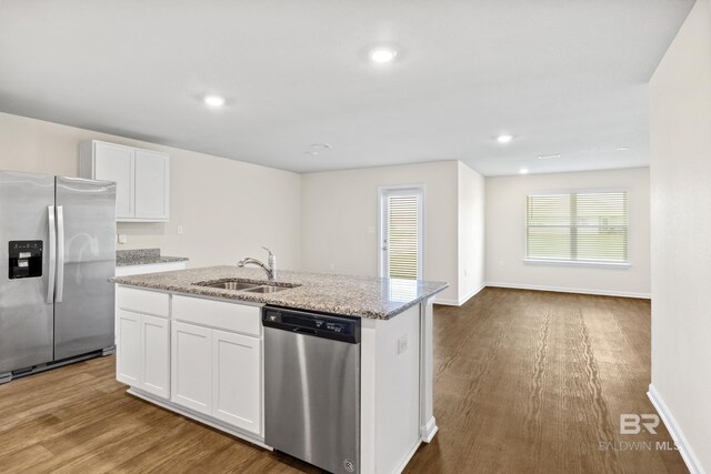 kitchen with light wood-type flooring, sink, white cabinetry, appliances with stainless steel finishes, and light stone countertops