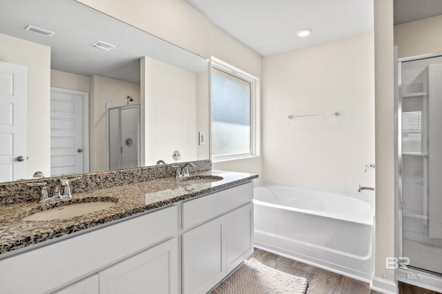 bathroom featuring vanity, plus walk in shower, and hardwood / wood-style flooring