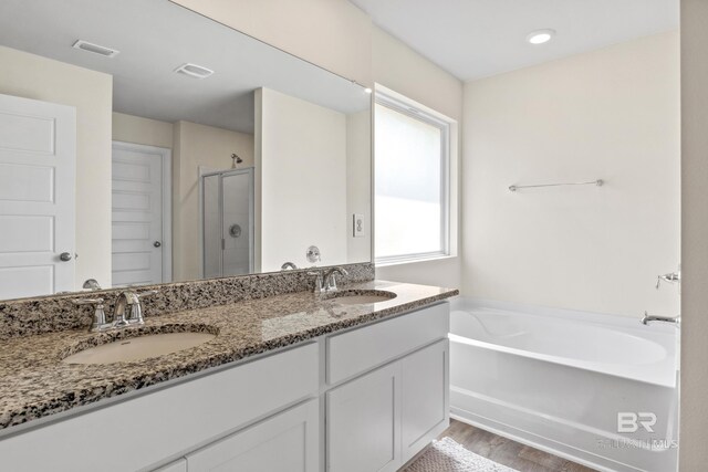 bathroom with separate shower and tub, vanity, and hardwood / wood-style floors