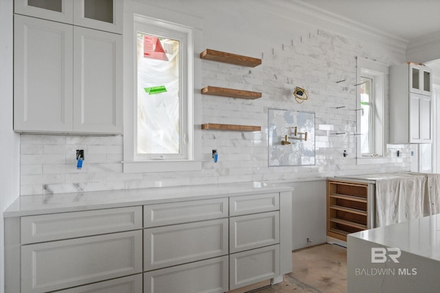16880 Brigadoon Trl, Gulf Shores, AL 36542 - kitchen featuring ornamental molding, decorative backsplash, and glass insert cabinets