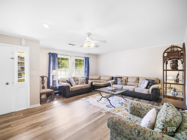 living room with light wood-type flooring, ceiling fan, and crown molding