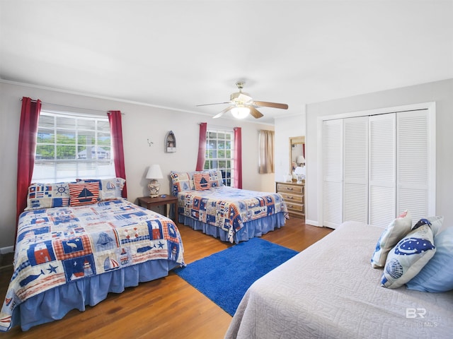 bedroom featuring a closet, hardwood / wood-style flooring, ceiling fan, and ornamental molding