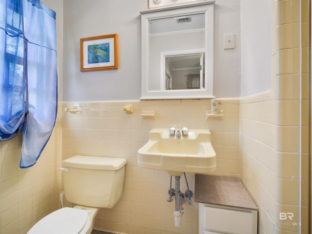 bathroom with tile walls and toilet