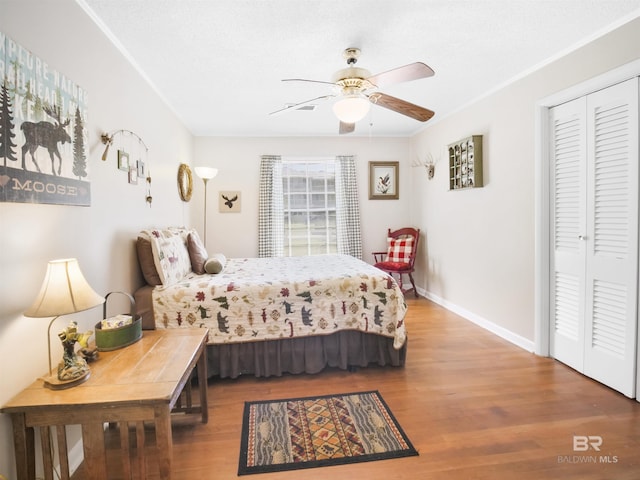 bedroom featuring wood-type flooring, a closet, and ceiling fan