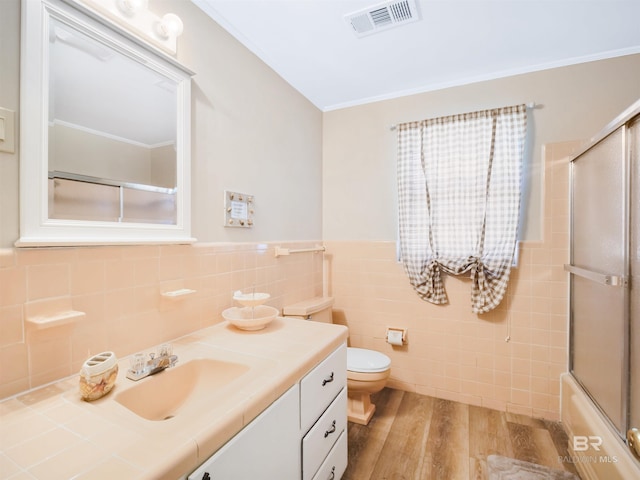 full bathroom with vanity, crown molding, hardwood / wood-style flooring, toilet, and tile walls