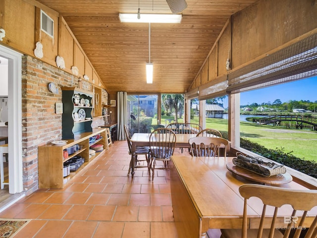 interior space with wooden walls, high vaulted ceiling, wooden ceiling, and a wealth of natural light