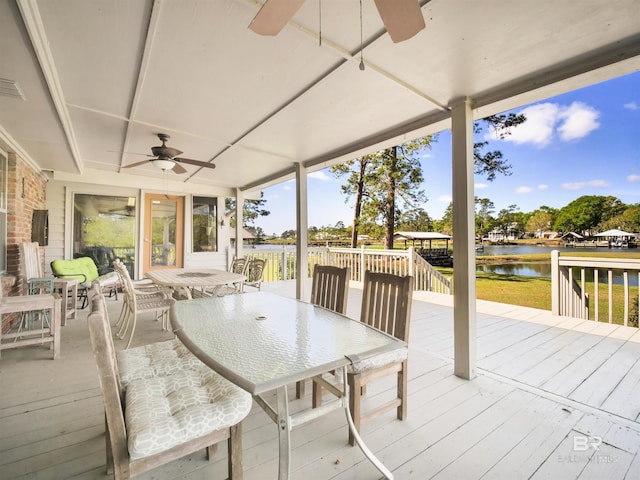 deck with a water view and ceiling fan