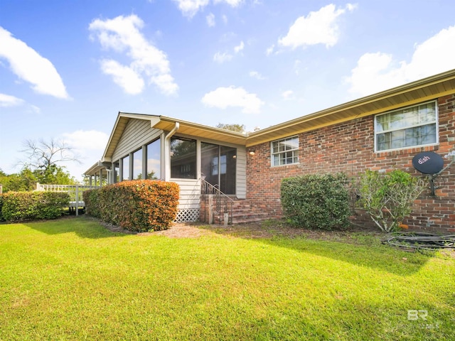 view of home's exterior featuring a yard and a sunroom