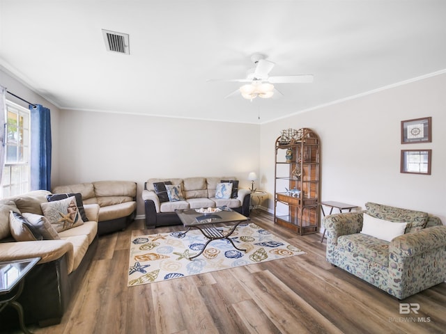 living room with ceiling fan, wood-type flooring, and ornamental molding