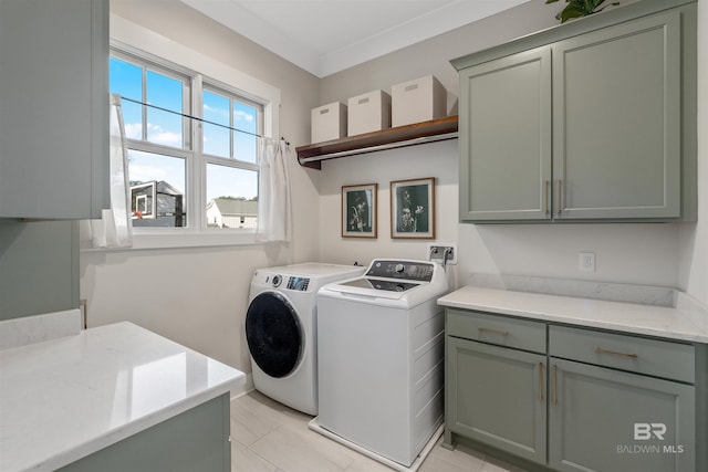 clothes washing area featuring cabinets, light tile patterned floors, crown molding, and washing machine and clothes dryer