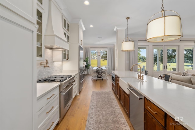 kitchen with white cabinets, a healthy amount of sunlight, high quality appliances, and pendant lighting