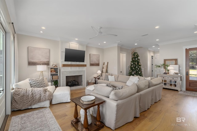 living room featuring crown molding, ceiling fan, and light hardwood / wood-style floors