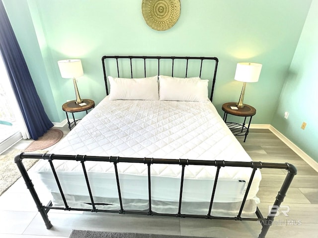 bedroom with baseboards and wood finished floors