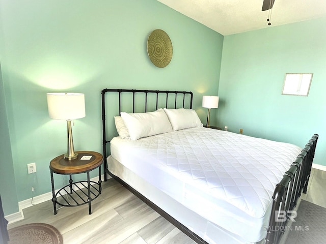 bedroom featuring ceiling fan, baseboards, and wood finished floors