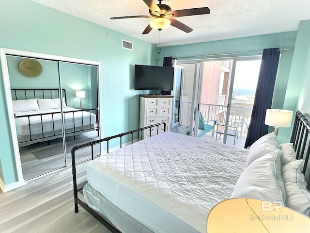 bedroom with wood finished floors, visible vents, ceiling fan, a textured ceiling, and access to outside